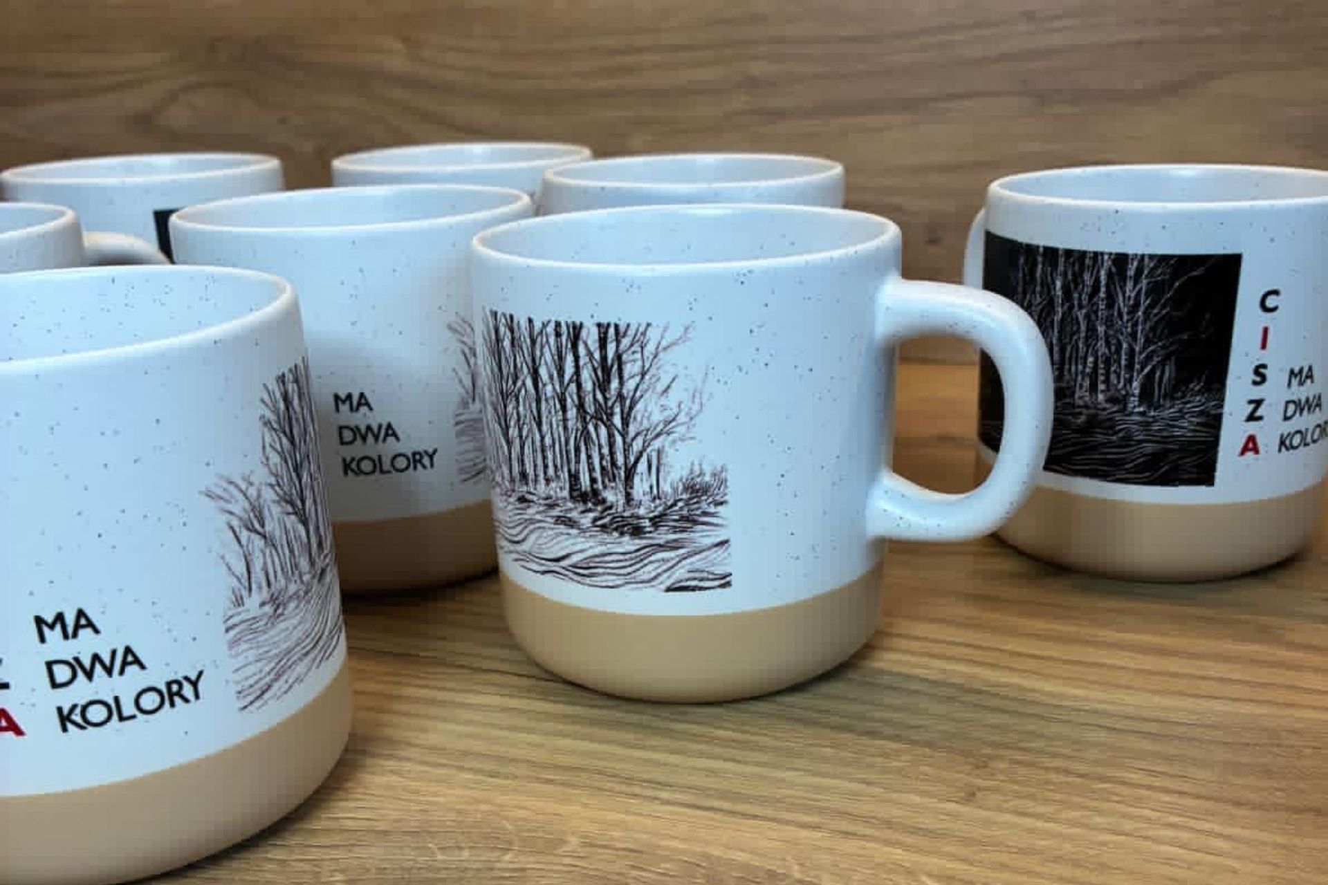 Ceramiczne kubki ALTO z grafiką brzóz, z cytatem „Cisza ma dwa kolory”.